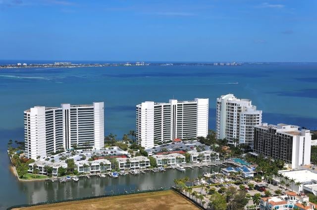 Aerial view of white high-rise residential buildings on waterfront with blue ocean and bay