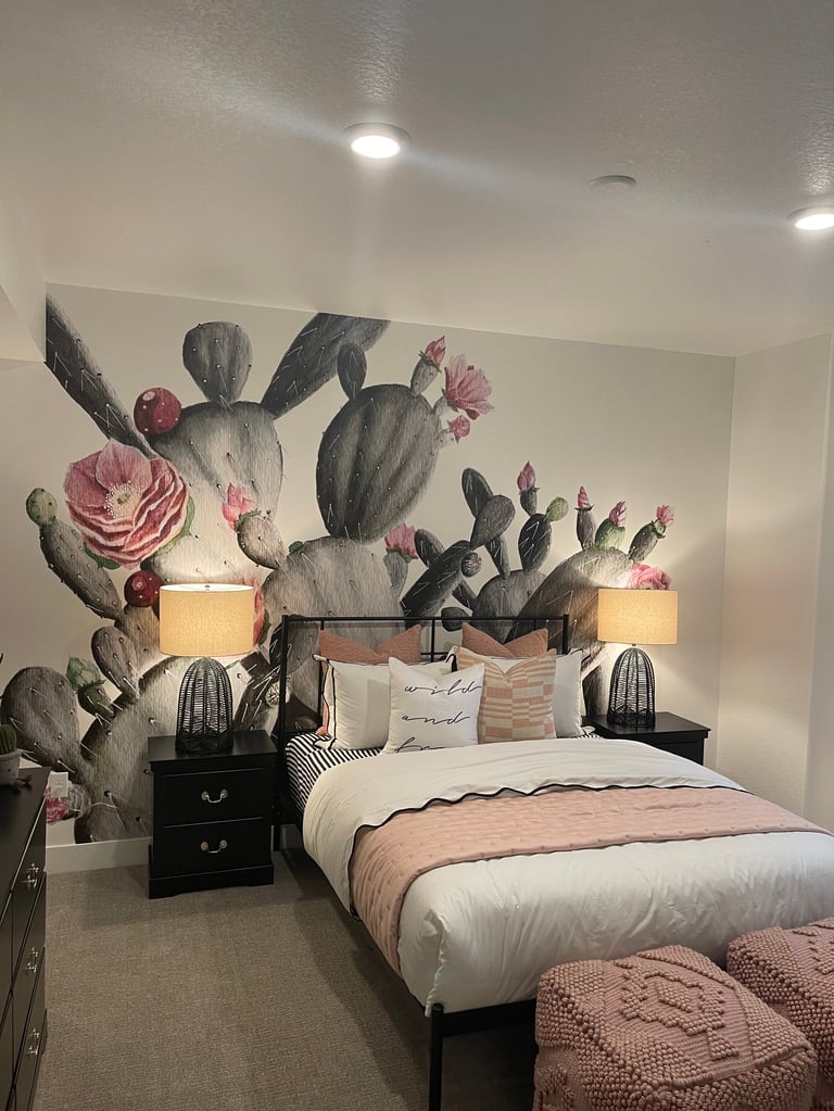 Modern bedroom with large cactus mural headboard, white bed, black nightstands, and decorative wall lights