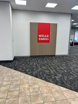 Wells Fargo logo on red sign mounted on vertical wooden slats wall