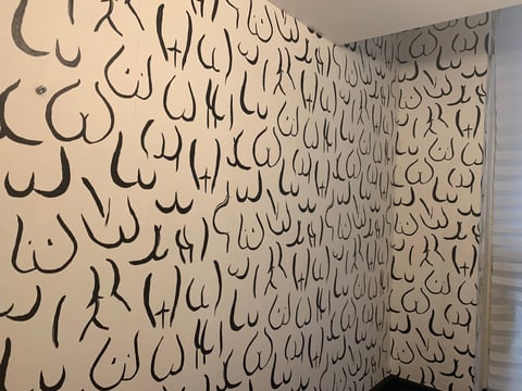 Beige wallpaper with repeating pattern of abstract curved line drawings in black ink