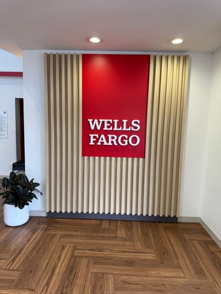 Wells Fargo bank interior with red logo sign on cream vertical blinds and wood floor