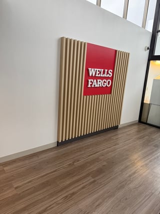 Wells Fargo logo sign mounted on wall with vertical wood slats