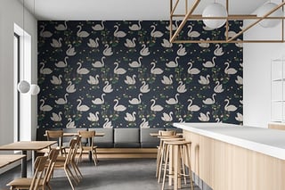 Modern cafe interior with swan-patterned dark wallpaper, wooden dining furniture, white counter, and geometric ceiling fixture
